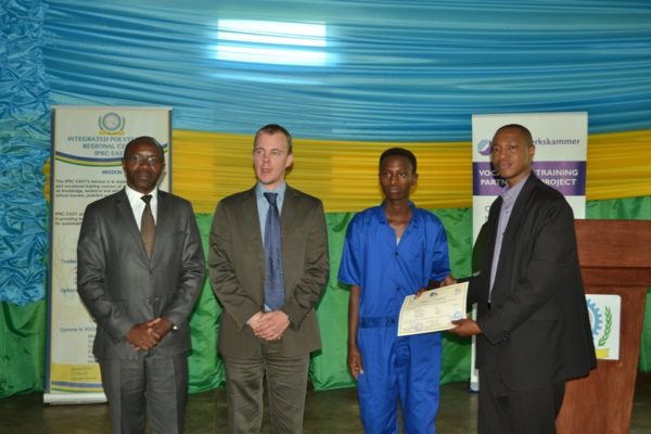 Abayobozi bashyikiriza impamyabushobozi umwe mu barangije amasomo