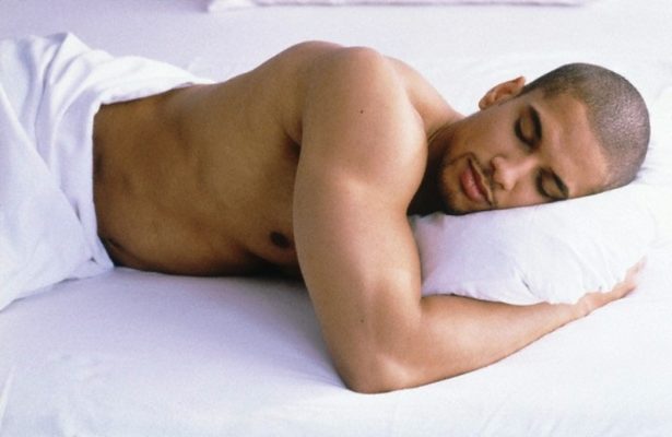 man sleeping in a bed --- Image by © A. Inden/Corbis